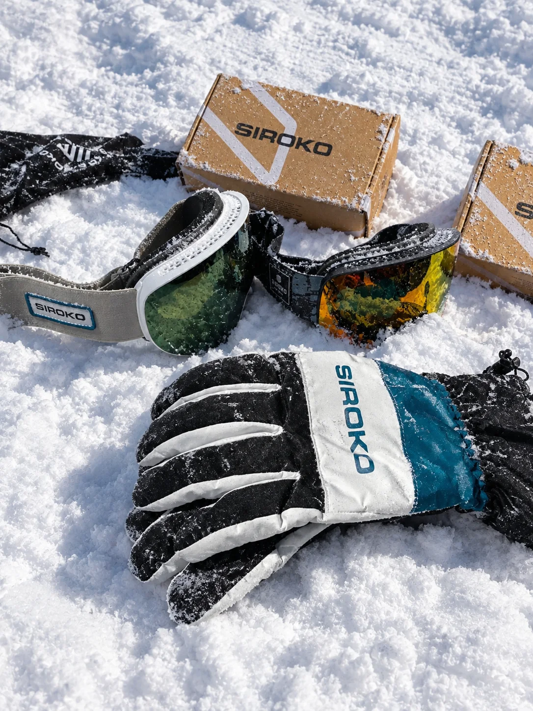 Mis máscaras y guantes Siroko sobre la nieve, con sus cajas